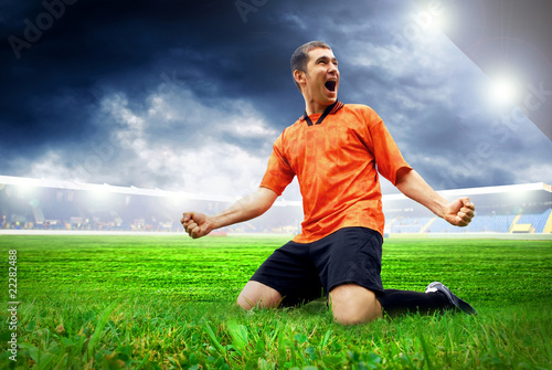 Fototapeta na wymiar Happiness football player after goal on the field of stadium wit