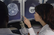 © Paul Burns/Blend Images - Hispanic female doctor pointing at brain scans