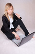 Beautiful business woman over laptop with ballpen in mouth