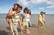 © micromonkey - Group Of Young Friends Walking Along Summer Shoreline