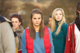 Fototapeta Londyn - Teenage Girl Surrounded By Friends In Outdoor Autumn Landscape