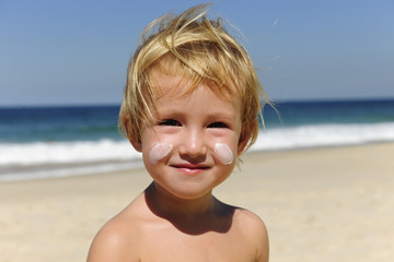 cute child with sunscreen  at the beach