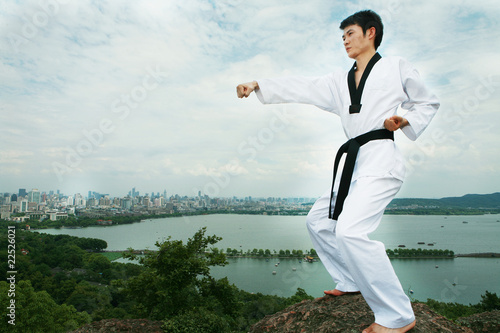 Naklejka samoprzylepna Jeden azjatycki mężczyzna gra z zewnątrz taekwondo