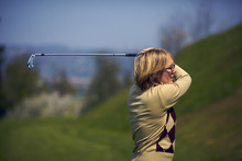 Portrait Of Woman Golfer After A Swing From Profile