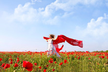 Beautiful Woman Running In Poppy Field With Red Scarf