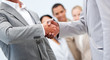 © WavebreakMediaMicro - Businessmen shaking hand in front of their colleagues