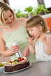 © CandyBox Images - Mother and child with chocolate cake in kitchen