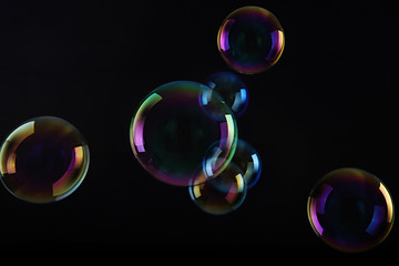 Soap bubbles on black background .