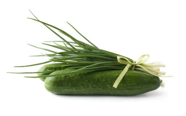 A bunch of green onions and cucumbers on a white background