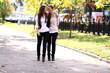 © Andrey_Arkusha - Fashionable girls twins walk in the street