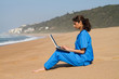 © michaeljung - intern using laptop on beach
