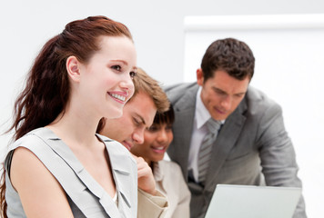 Wall Mural - Portrait of a smiling businesswoman working with her colleagues