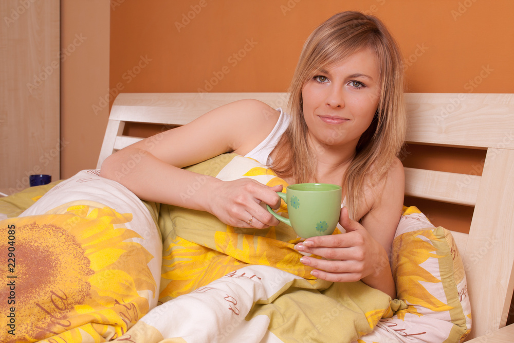 Bautiful young woman on a bed and drinking cofee - obrazy, fototapety, plakaty 
