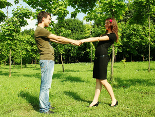 young man and girl keep for hands outdoor