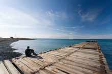 Man Sitting At Pier
