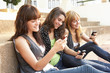 © Monkey Business - Group Of Teenage Students Sitting Outside On College Steps Using