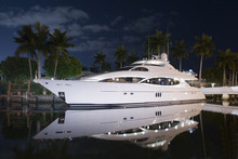 Night Shot Of Luxury Yacht Docked By The House In Canal Palm Trees And Moon Light
