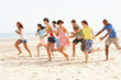 © micromonkey - Group Of Friends Running Along Beach Together