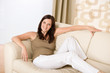 © CandyBox Images - Smiling woman relax on sofa in lounge