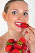 junge Frau beisst in eine Erdbeere