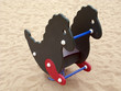 Rocking horse in sand outdoors