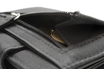 Black wallet opened with coins inside on white