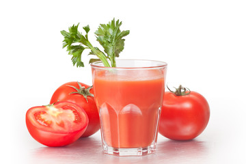 Fresh tomatoes and a glass full of tomato juice.