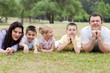 © get4net - Cheerful family of five lying on lawn in the green park