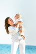 © Alena Yakusheva - happy mother playing with son on sea background