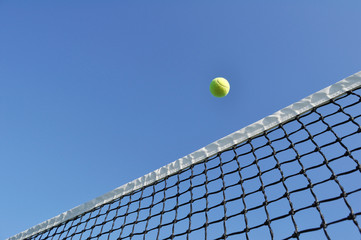 Yellow Tennis Ball Flying Over the Net