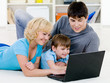 © Valua Vitaly - Happy family looking in laptop together