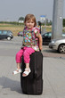 Kind auf Koffer am Flughafen auf Reise