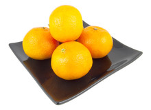 Five Oranges On Black Plate Isolated On White