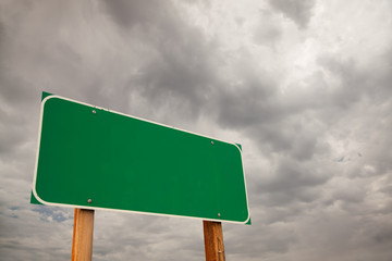 Blank Green Road Sign Over Storm Clouds