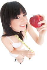 Wall Mural - Fun woman with red apple and measure tape on the glass scales