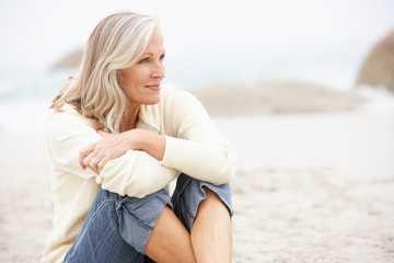 Wall Mural - Senior Woman On Holiday Sitting On Winter Beach