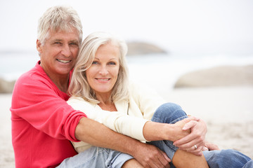 Wall Mural - Senior Couple On Holiday Sitting On Winter Beach