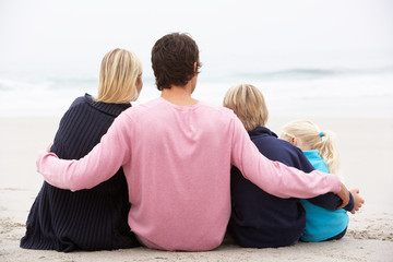 Wall Mural - Back View Of Young Family Sitting On Winter Beach