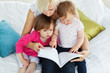 © WavebreakMediaMicro - Cute mother reading a book with children