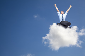 young businessman with computer sitting on the cloud