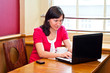 © rauf_ashrafov - young woman using laptop and drinking cappucino in a cafe