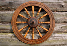 Spinning Wheel On Log House Wall