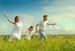 Happy family running on a meadow