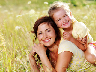 happy mother and little daughter on nature