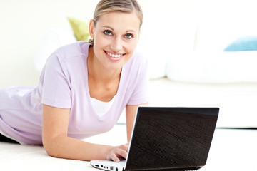 Wall Mural - Positive woman using her laptop on the floor