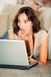 © goodluz - Woman with surprised look in front of computer