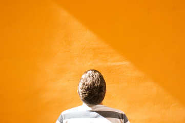 Man looking at the orange wall