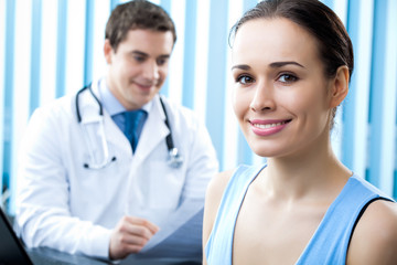 Happy female patient and doctor at office