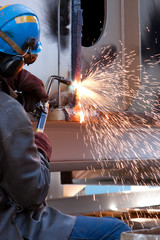 Wall Mural - worker inside factory cut metal using blowtorch