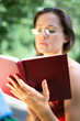 © volff - girl reading a book in the park.